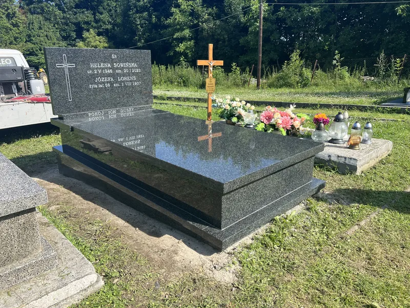 Grobowiec Impala ze stelą z tablicą i drewnianym krzyżem z kwiatami na płycie, letni cmentarz Kraków, realizacja Kamileo.