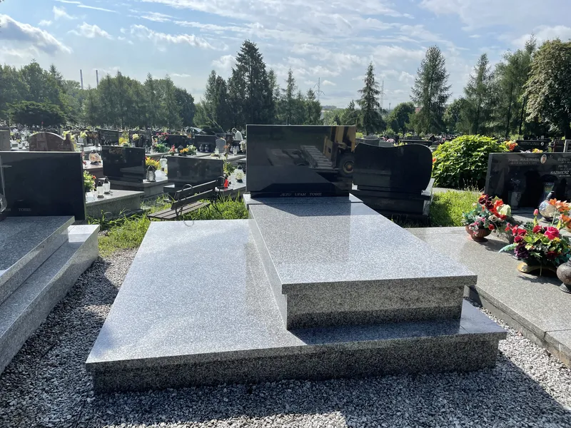 Podwójny grobowiec Tarn z czarną płytą Impala, dwie połączone kwatery, widok od nóg, błękitne niebo, cmentarz Kraków, Kamileo.