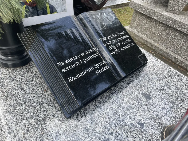 Rzeźbiona granitowa książka z wygrawerowanym wierszem i dedykacją jako element zdobniczy nagrobka, realizacja Kamileo Kraków.