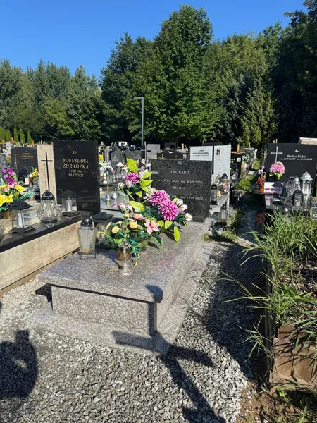 Nagrobek z granitu Brąz Królewski z czarną stelą wieloosobową w słonecznym letnim ujęciu, cmentarz Kraków, realizacja Kamileo.