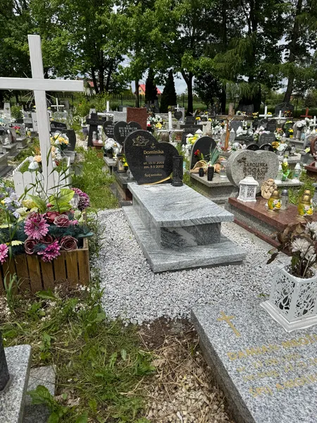 Mały nagrobek dziecięcy z jasnego granitu Viscount White z czarną tabliczką Monumental i bogatą dekoracją kwiatową, cmentarz Kraków, Kamileo.
