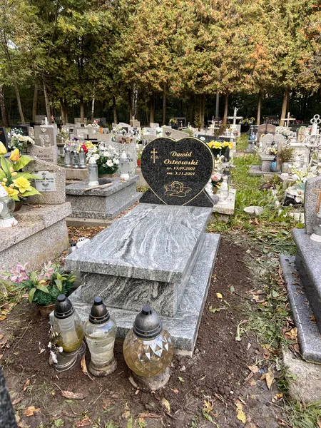 Dziecięcy nagrobek z jasnej płyty Viscount White z czarną stelą serce Monumental, jesienne otoczenie cmentarza Kraków, realizacja Kamileo.