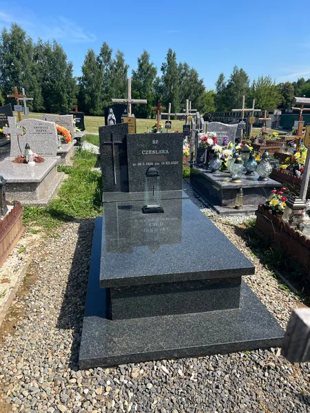 Nagrobek Impala ze stelą z tablicą i szklaną aplikacją, szerokie letnie ujęcie na krakowskim cmentarzu, realizacja Pracowni Kamileo.