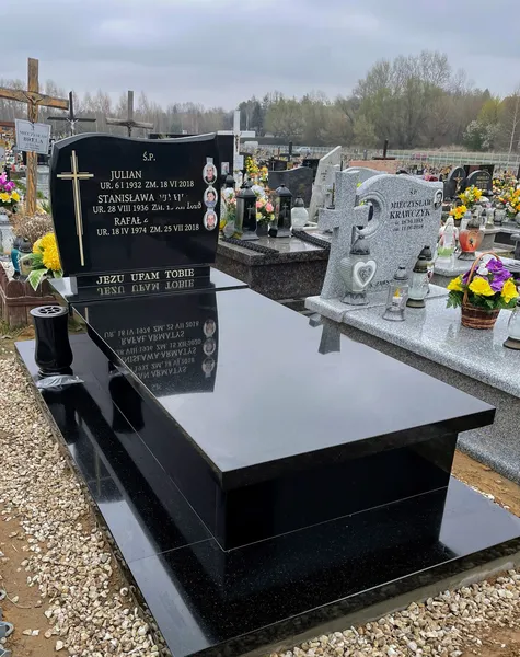 Czarny grobowiec rodzinny z granitu Monumental z wieloosobową tablicą inskrypcyjną, realizacja Kamileo Kraków.