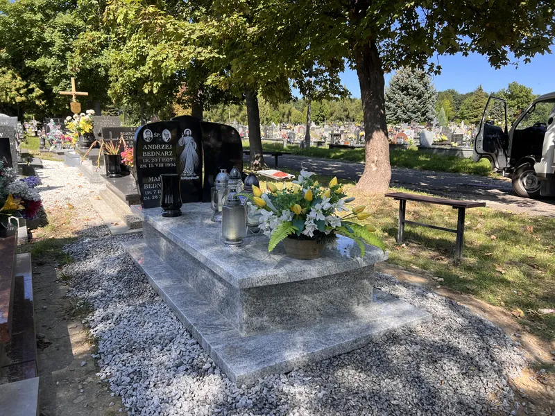 Nagrobek jednopłytowy Viscount White z czarną łukową stelą Monumental z portretem, świeży montaż na letnim cmentarzu, realizacja Kamileo Kraków.