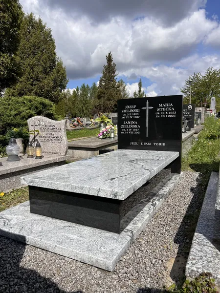Nowoczesny pomnik jednopłytowy Viscount White z czarną stelą Monumental na tle dramatycznego nieba, cmentarz Kraków, realizacja Kamileo.