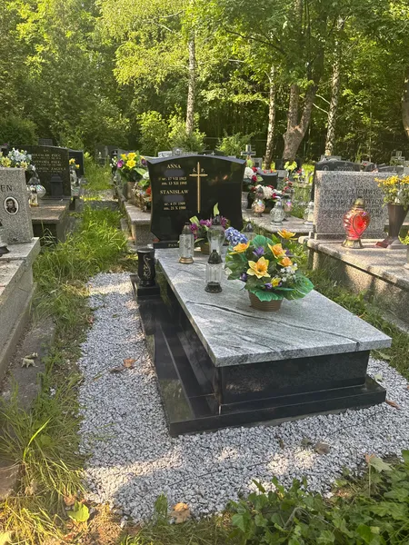 Ujęcie ukośne nagrobka Viscount White z czarną stelą Monumental na tle brzóz cmentarnych w Krakowie, realizacja Pracowni Kamileo.