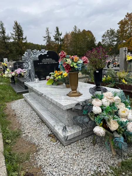 Nowoczesny pomnik jednopłytowy z falistego granitu Viscount White z rzeźbioną attyką z czarnego granitu Monumental, realizacja Kamileo Kraków.