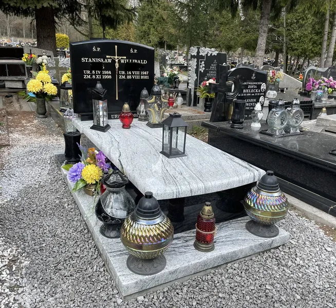 Pomnik jednopłytowy Viscount White z czarną stelą Monumental z obfitą dekoracją lampionów i kwiatów na cmentarzu, realizacja Kamileo Kraków.